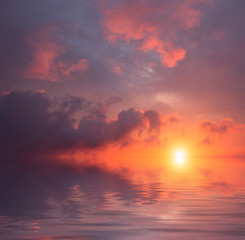 Storm clouds against the background of a blood-red sunset and a calm sea.