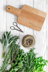 drying fresh herbs and greenery for spice food on white wooden kitchen desk background top view space for text
