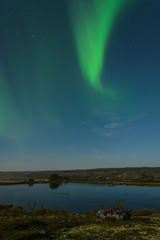 Autumn Aurora, the polar lights in the sky over the river,lake and hills at night .