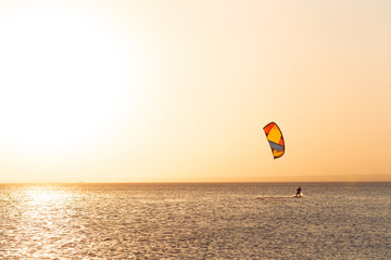 Kitesurfing at sunset at sea