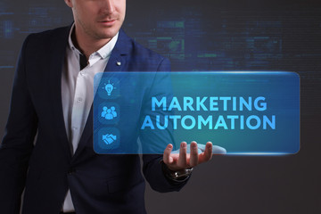 Business, Technology, Internet and network concept. Young businessman working on a virtual screen of the future and sees the inscription: Marketing automation