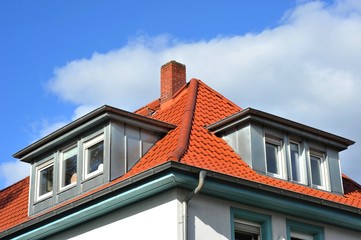 Ziegeldach mit modernisierten Metall-Stehfalz-Dachgauben und Kamin