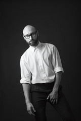 Obraz premium young white beard wearing glasses man white shirt black pants studio monochrome background