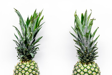 Fototapeta premium Tropical fruits background. Pinneapple on white top view