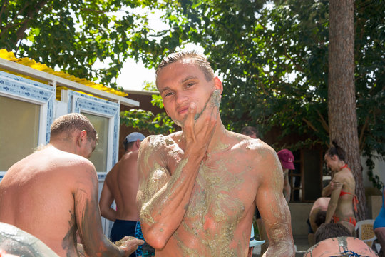 The young man is smeared with mud near the thermal spring