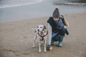 Woman With Dog On A Winter Beach