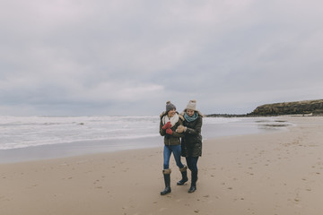 Young Women Walking Along A Winter Beach