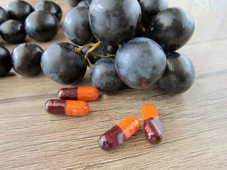 vitamin pills on a wooden floor,grapes,Iron,vitamin,vitamins,health.