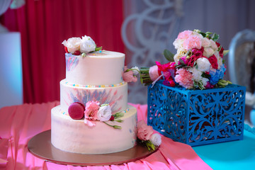 Big sweet multilevel wedding cake decorated with flowers. Concept of candy bar on party