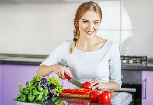 A young woman is preparing food in the kitchen. Vegetarian. The concept is healthy food, diet, vegetarianism, weight loss.