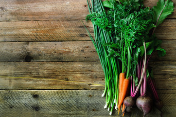 Fresh vegetables - carrots, beetroots, green onion on wooden background. Harvest. Concept of diet, raw, vegetarian meal.