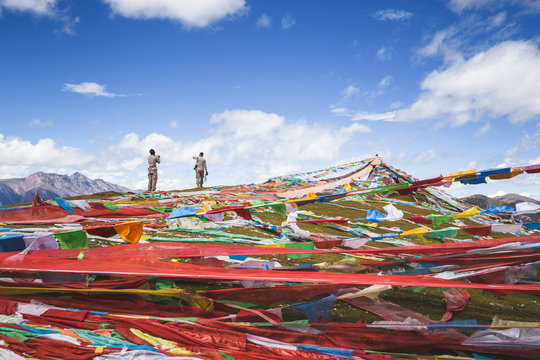 young couple take picture stand beside prayer flags