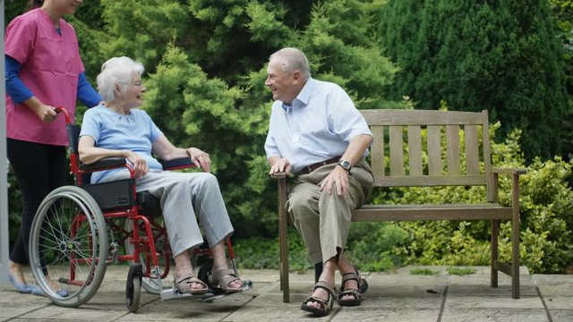 Cheerful elderly residents of nursing home spending time outdoors in the garden.