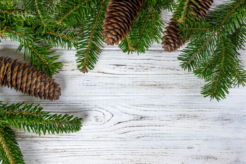 christmas fir tree with pine-cones on a wooden board