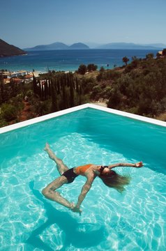 Handsome woman with long hair playing in the pool