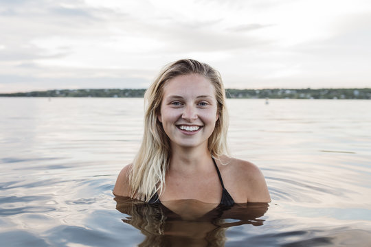 Happy young woman in calm lake