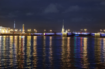 Fototapeta na wymiar Night view of the University embankment of St. Petersburg through the Neva River- Peter and Paul fortress, Palace bridge, Vasilievsky island