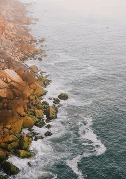 Waves and rocks in a misty day