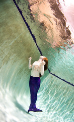 A woman with red hair in below or above the surface.