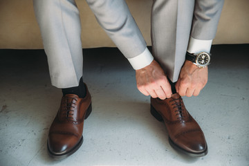 man wears shoes. Tie the laces on the shoes. Men's style. prepare for work, to the meeting