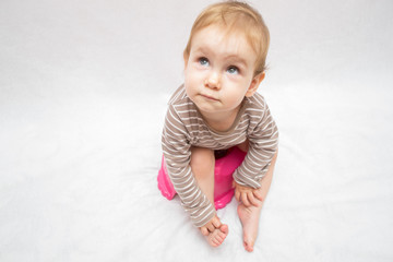 Toddler girl potty trainting isolated on white background - obrazy, fototapety, plakaty