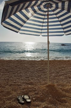 Umbrella and thongs on the beach