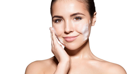 Young girl cleans a clean healthy skin with facial foam and smiling looking into the camera....