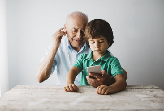 Grandfather and grandson listening to music