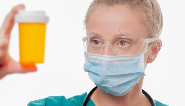 Female doctor, nurse holding a bottle of pills on white background.