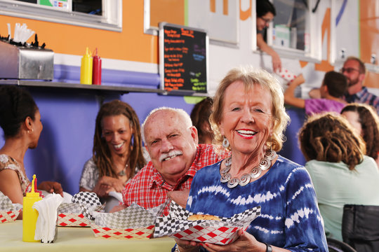 Smiling Senior Couple Have Lunch At A Food Truck