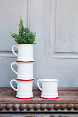 White ceramic mugs with pine tree on wooden trays