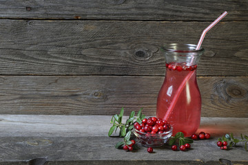 Cowberry and cowberry mors on a gray wooden background © ferumov