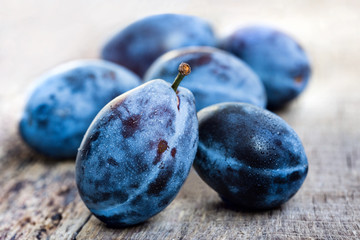 Fresh ripe plums on a wooden background