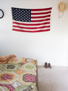 American flag and straw hat hanging on wall of bedroom