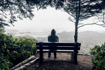 Man sitting on bench overlooking sea on Vancouver Island