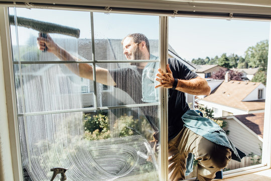Window Washer Cleaning Outside Of Bedroom Window At Condo