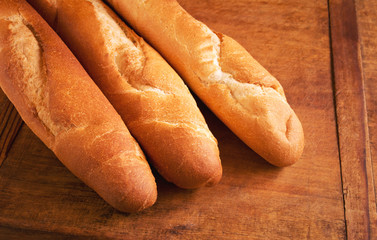 Golden French baguettes on wooden table, fresh bread for breakfast