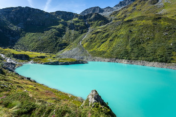 un lac bleu émeraude au milieu des montagnes