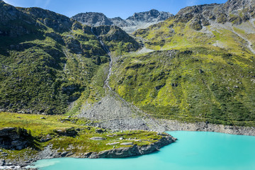Fototapeta na wymiar les sources d'un lac bleu au milieu des montagnes vertes 