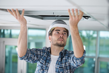 handsome builder replacing ceiling panel