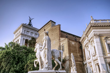 Marble statues of the Dioscuri, Castor and Pollux, at the top of the staircase, in Capitol Square or Piazza del Campidoglio, Rome, Italy. Basilica of Santa Maria in Aracoeli in background