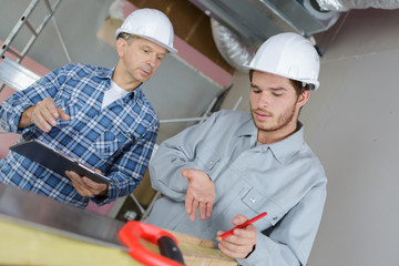 engineer and apprentice working in factory