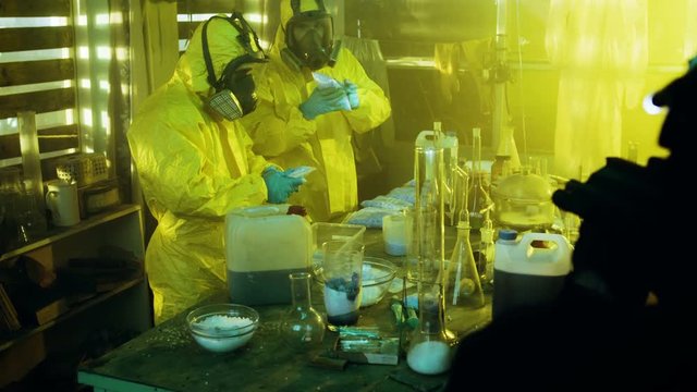 Fully Armed Special Anti-Narcotics Task Forces Soldier Arrests Two Clandestine Chemists Working in the Illegal Drug Producing Underground Laboratory. 