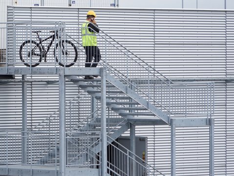 Fahrrad auf einer Stahltreppe vor einer Blechfassade 