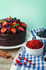 Chocolate cake with berries in plate on wooden table