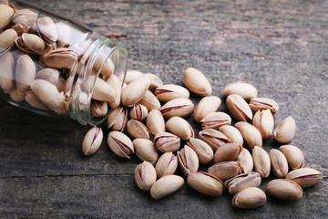 Pistachios in bottle on grey wooden table