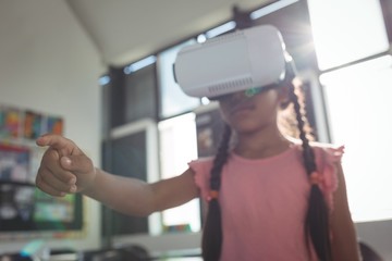 Fototapeta na wymiar Girl wearing virtual reality simulator in classroom