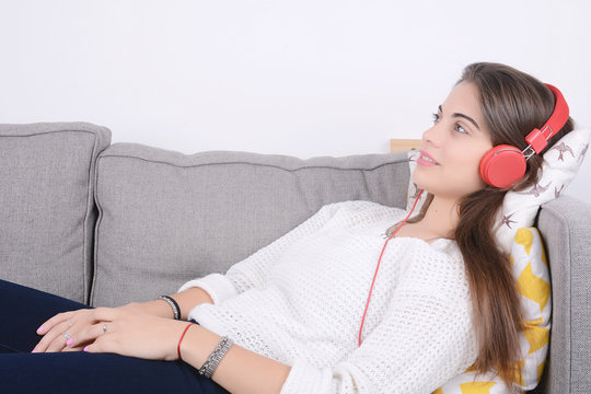 Woman listening music on couch.