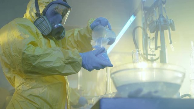 In the Underground Laboratory Clandestine Chemists in Protective Coveralls Pack Newly Cooked Batch of Blue Crystal Meth in the Bags for Further Street Distribution. 