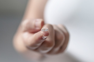 Young woman with contact lens on her finger.